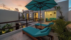 A rooftop terrace with lounge chairs, a table, and an umbrella. - Villa Irena (Canggu)
