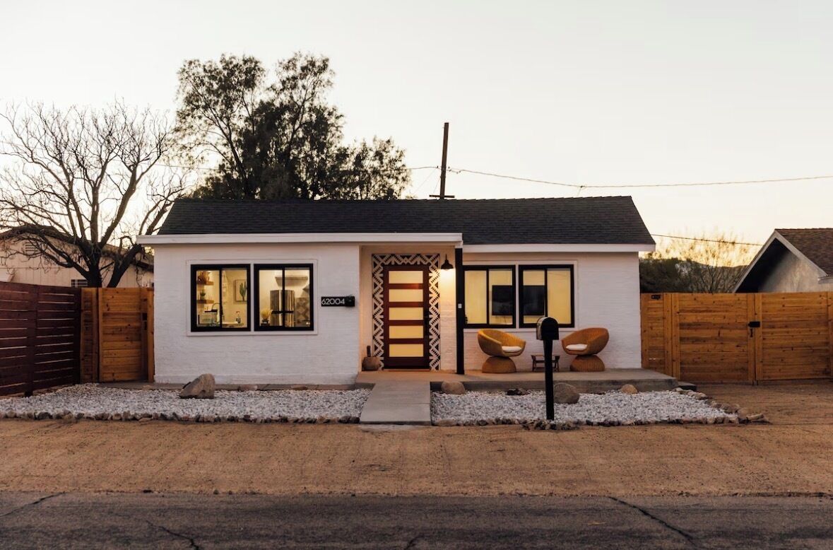 A single-story house with a front door, windows, and a small porch area.
