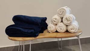 A stack of towels on a wooden stool against a wall. - Mall Suite at Sunsuria Forum by HCK (Shah Alam)