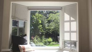 Une baie vitrée donnant sur un jardin.