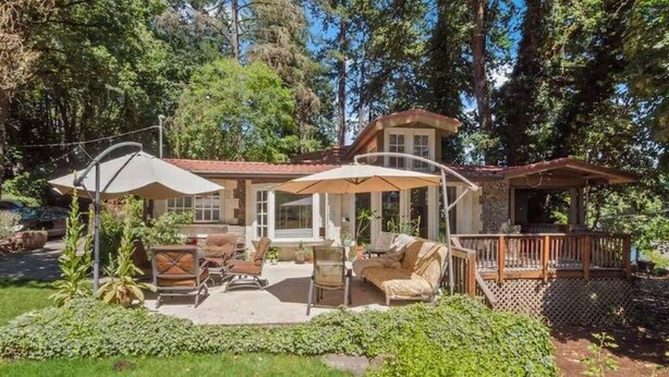 Une maison avec un patio, du mobilier d’extérieur et une terrasse.