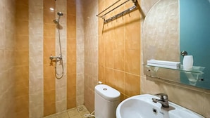 A bathroom with a toilet, sink, shower, and a glass shelf with a towel rack.