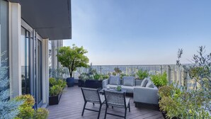 A rooftop terrace with a sofa, chairs, and potted plants. - Ascott Hankou Riverside Wuhan (Wuhan)