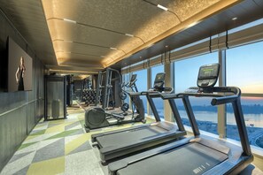 A gym with treadmills, elliptical machines, and weight equipment.