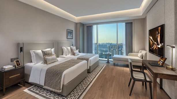A modern hotel room with two beds, a desk, a chair, a TV, and a city view. - Ascott Hankou Riverside Wuhan (Wuhan)