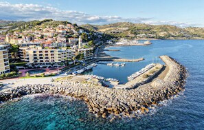 Une ville côtière dotée d’un port de plaisance, d’une digue rocheuse et d’immeubles d’habitation.