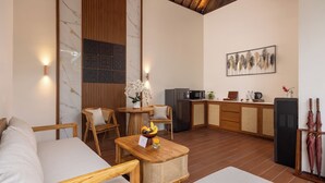 Un interno moderno con un divano, mobili in legno, un tavolo da pranzo, un angolo cottura e un'opera d'arte appesa al muro.