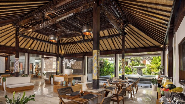 Un'ampia hall con soffitto alto, arredi in legno e vista sull'esterno.