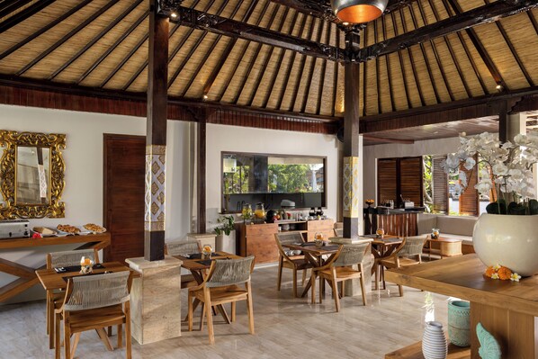 Una habitación amplia con techo alto, muebles de madera, un espejo grande y un televisor.