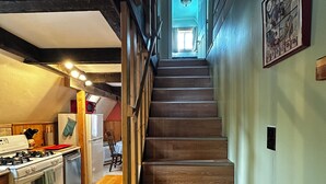 A staircase leading to a second floor with a kitchen area on the left.
