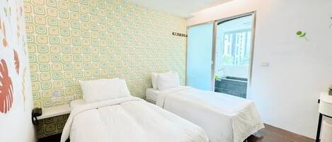 A room with two beds, a window, and a door leading outside.