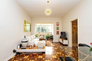 A modern living room with a sofa, coffee table, and a large window. - Lux Casa SP • 3BR + Private Studio • Av. Paulista, Bela Vista, Downtown (São Paulo)