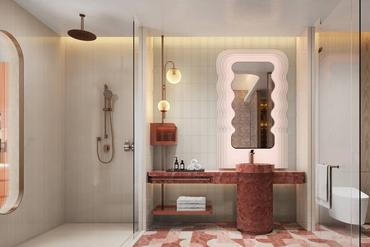 A modern bathroom with a glass shower enclosure, a marble vanity, and a large mirror with a unique wavy frame.