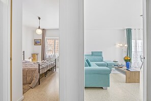 A modern living room with a sofa, a coffee table, and a bed with a headboard. - Holiday On The Sea - Seafront Apt, Menton, France (Menton)