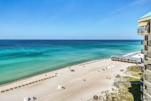 A beachfront hotel with a sandy beach, a pool area, and a view of the ocean. - Emerald Breeze-Gulf Front Sunbird Condo-Pools + Beach Access-Sleeps 4 (Panama City)