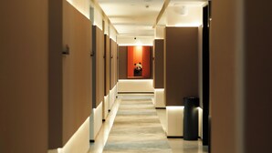 Corridoio di un hotel con diverse camere, una decorazione a forma di panda e un cestino.