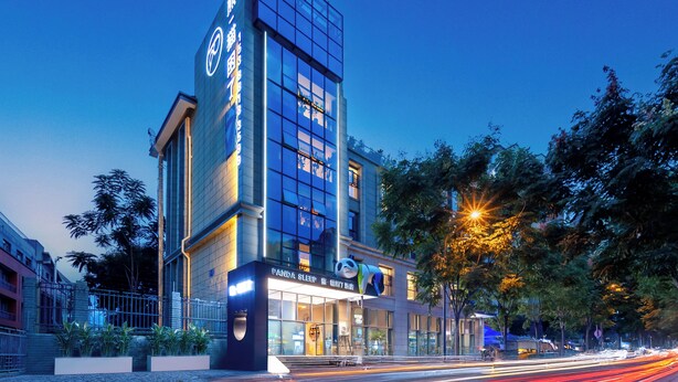 Un edificio moderno con facciata in vetro, il logo di un panda e la scritta 'Panda Sleep' sulla facciata.
