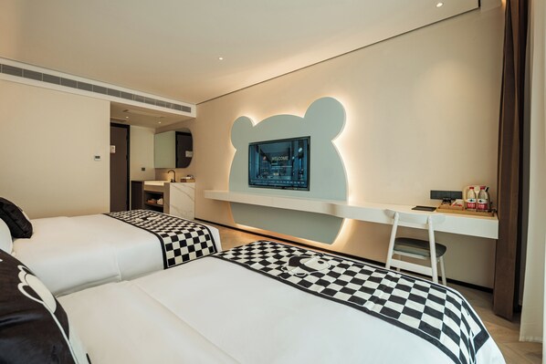 Une chambre d’hôtel avec deux lits, un bureau, une chaise, une télévision et un lampadaire en forme d’ours.