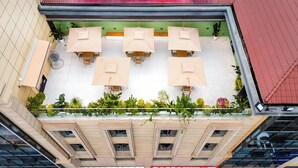 Una terrazza sul tetto con posti a sedere all'aperto e piante in vaso.