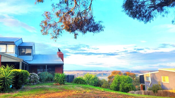 A modern house with a sloped roof, a garage, and a well-maintained garden.