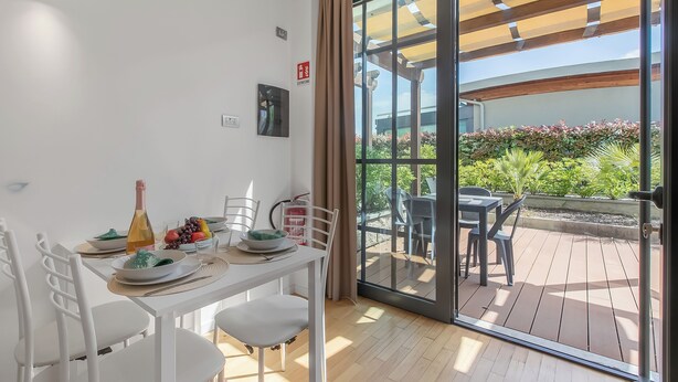A dining area with a table set for two, a bottle, and a bowl of fruit. - Mediterranea 35 in Savona, Savona, Italy (Savona)
