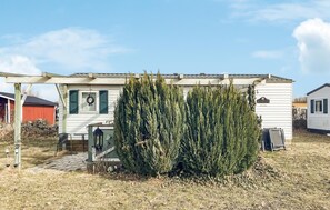 A white mobile home with a porch, a small garden, and a sign that reads 'LE COTTAGE.' - 3 bedroom stunning home in Färjestaden (Färjestaden)