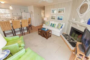 A living room with a sofa, chairs, a coffee table, a fireplace, and a television. - Beach Happy - North End VB (Virginia Beach)