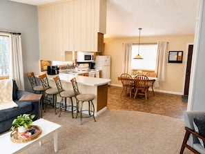 Un appartement moderne comprenant une cuisine, un coin repas et un salon.