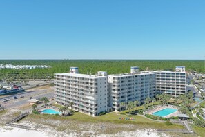 Ein mehrstöckiges Hotel mit Pool und Zugang zum Strand.