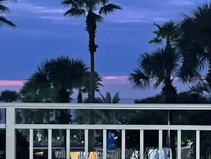 A balcony with a view of palm trees and a sunset. - Beachfront • Lazy River • Sleeps 8 • C305 (Fort Walton Beach)