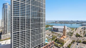 A high-rise building with a grid-like facade, a large water body with a pier in the background, and a historic building with a dome. - 501 First Luxury Ocean View from Balcony Rooftop Pool & GYM 3511 (Miami)