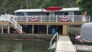 Une propriété située au bord de l’eau, dotée d’un quai, d’un espace abrité avec un parasol rouge et d’un drapeau.