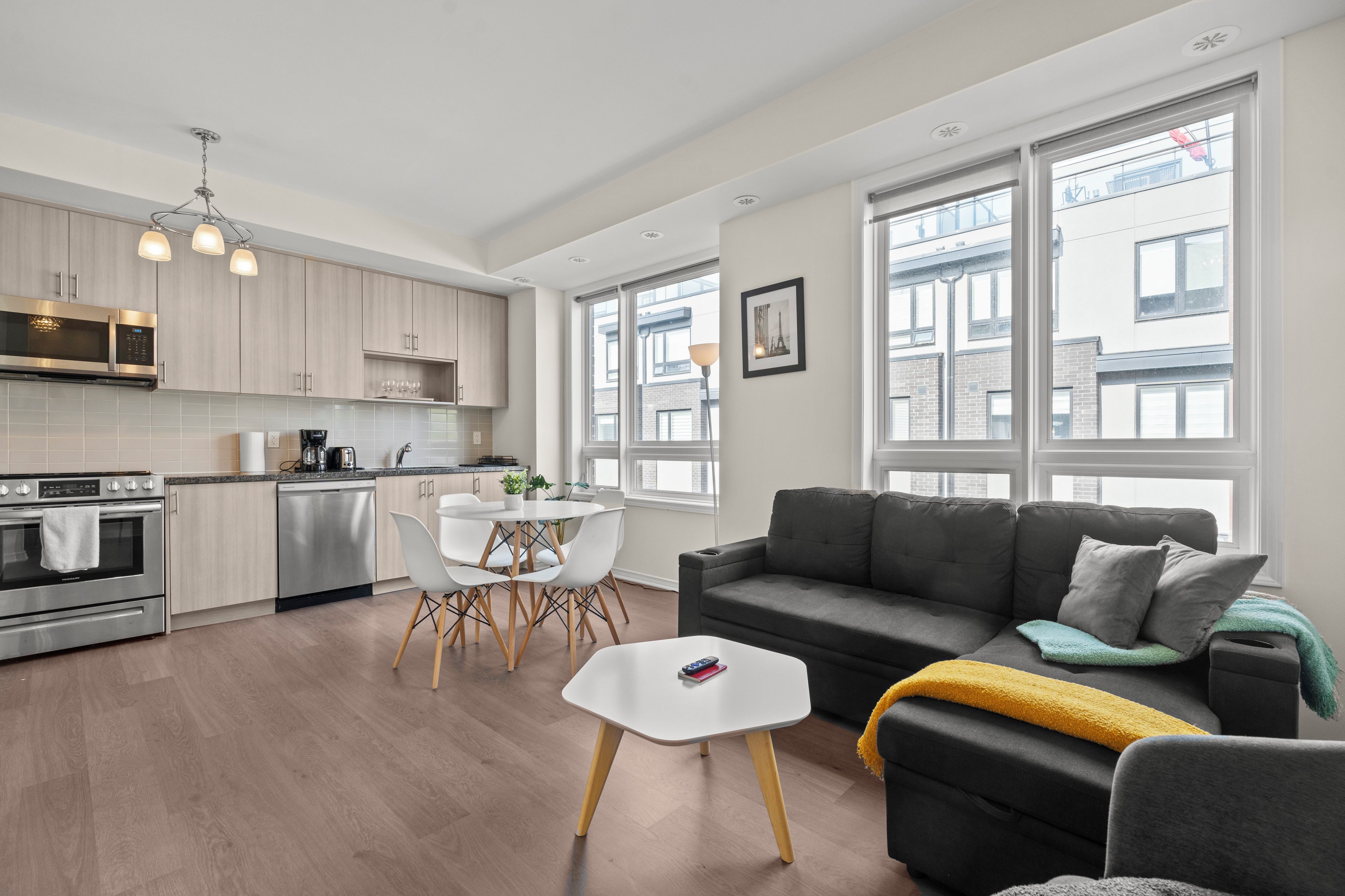 A modern apartment with a kitchen, dining area, and living room.