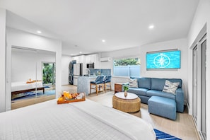 Une chambre d’hôtel moderne comprenant un lit, un canapé, un coin repas et une cuisine.