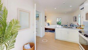 A modern kitchen with white cabinets, a built-in oven, and a large island with a sink. - Walk to Beach / Shared Heated Pool / LostShaker Two (Lauderdale-by-the-Sea)