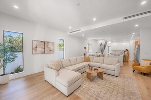 Una sala de estar moderna con un sofá modular, una mesa de centro y un comedor.