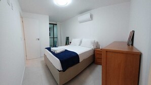 A bedroom with a bed, bedside table, and a desk. - Fantastic Apartment by the Beach, 24/7 Security, Parking Garage (Vila Velha)