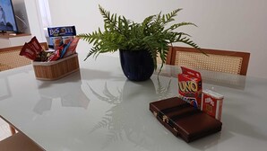 A table with a plant, a box of UNO cards, and a small brown bag. - Fantastic Apartment by the Beach, 24/7 Security, Parking Garage (Vila Velha)
