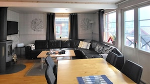 A living room with a sofa, a wooden table, and a television.