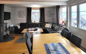 Ein Wohnzimmer mit einer Couch, einem Holztisch und einem Fernseher.