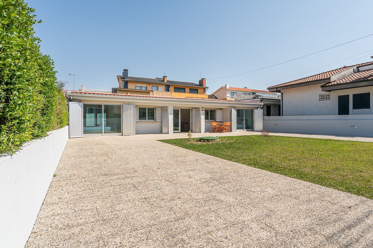 Una casa moderna con un patio, un comedor y un espacio exterior cubierto.