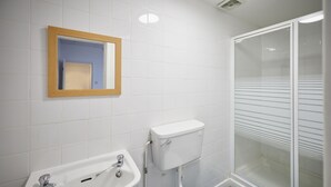 Un baño con lavamanos, inodoro y ducha.