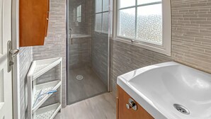 Ein Badezimmer mit einer großen Badewanne, einer Duschkabine und einem Fenster mit Blick.