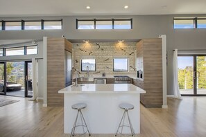 Una cocina moderna con una isla central, ventanas amplias y vistas al exterior.