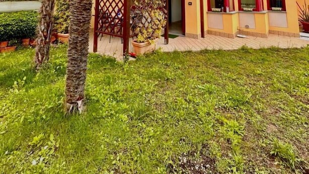 A multi-story building with a flat roof, a balcony, and a gated entrance. - TRILO OSIMO MARCELLI - Delightful three-room apartment with garden near the sea (Marcelli)