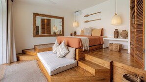 Ein Schlafzimmer mit einem Bett, einem Spiegel, einem Deckenventilator und Holzboden.