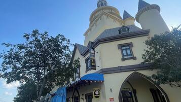 A building with a turreted tower, a blue awning, and a sign for a coffee and tea shop.