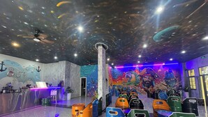 A room with a space-themed mural, a reception desk, and colorful barrels labeled 'WIN HOUSE'. - Win House Hotel (Phu Quoc)