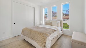A bedroom with a bed, a window, and a door. - Cozy Midtown Retreat 2BR/2BA PRIVATE GARAGE (Sacramento)