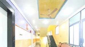A hallway with a ceiling fan, a staircase, and a bench. - La Palace (Guduvancheri)